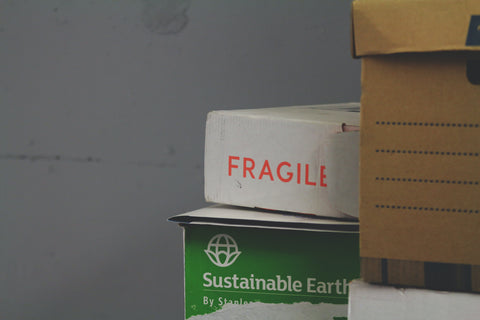 A stack of moving boxes, one of which is clearly labeled "FRAGILE"