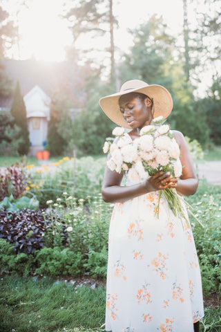 person in garden holding flowers, photo provided by re.Planted Farm & Floral Studio for West Coast Seeds