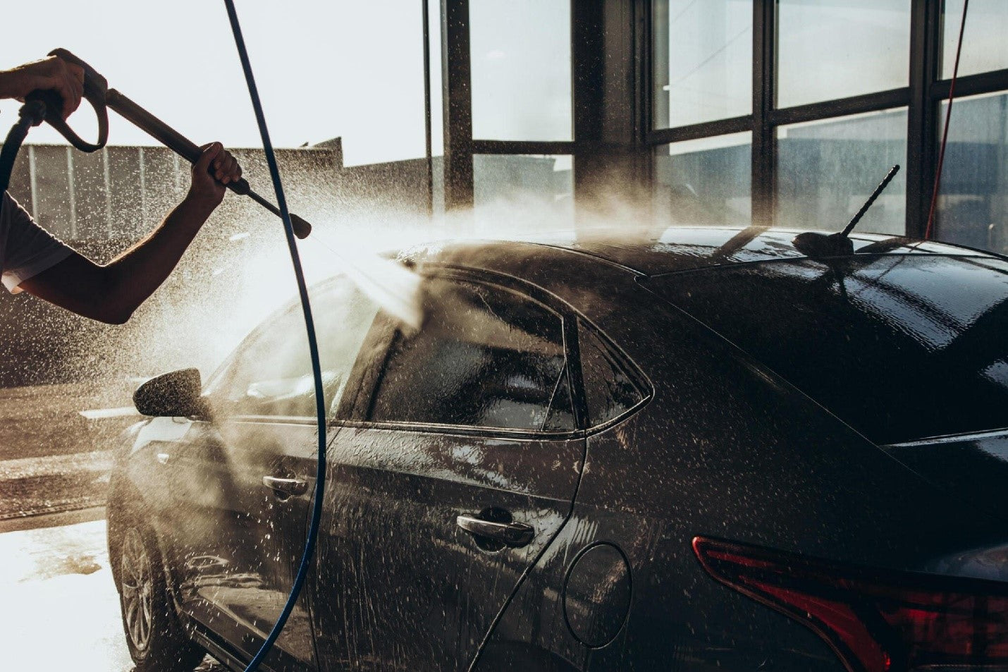 A man washes his car at a self-service car wash using a hose with pressurized water carcarez blog