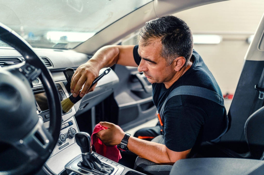 Professional worker cleaning car interior and dashboard car carez