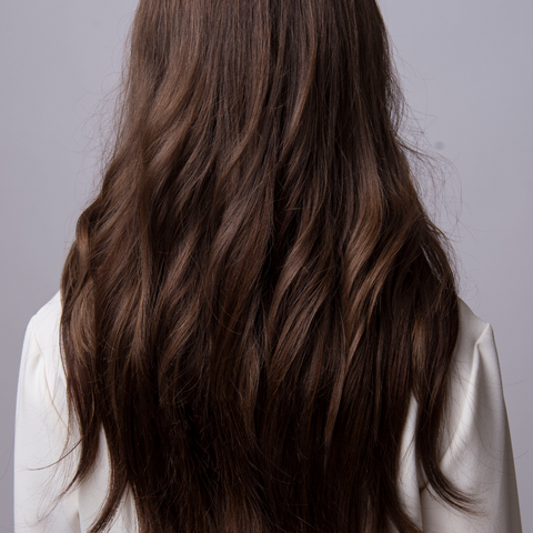 female with long brown hair waved with a straightner