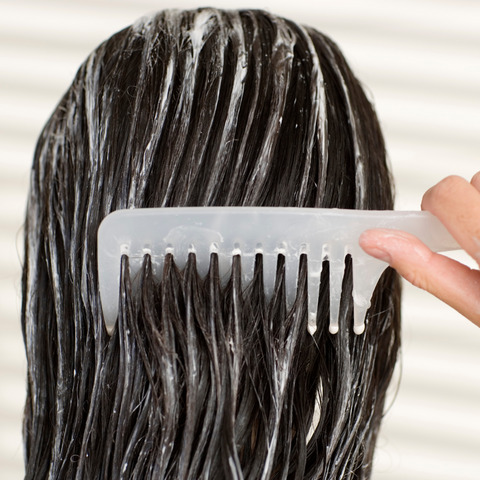 Female using a leave an over night treatment in hair 