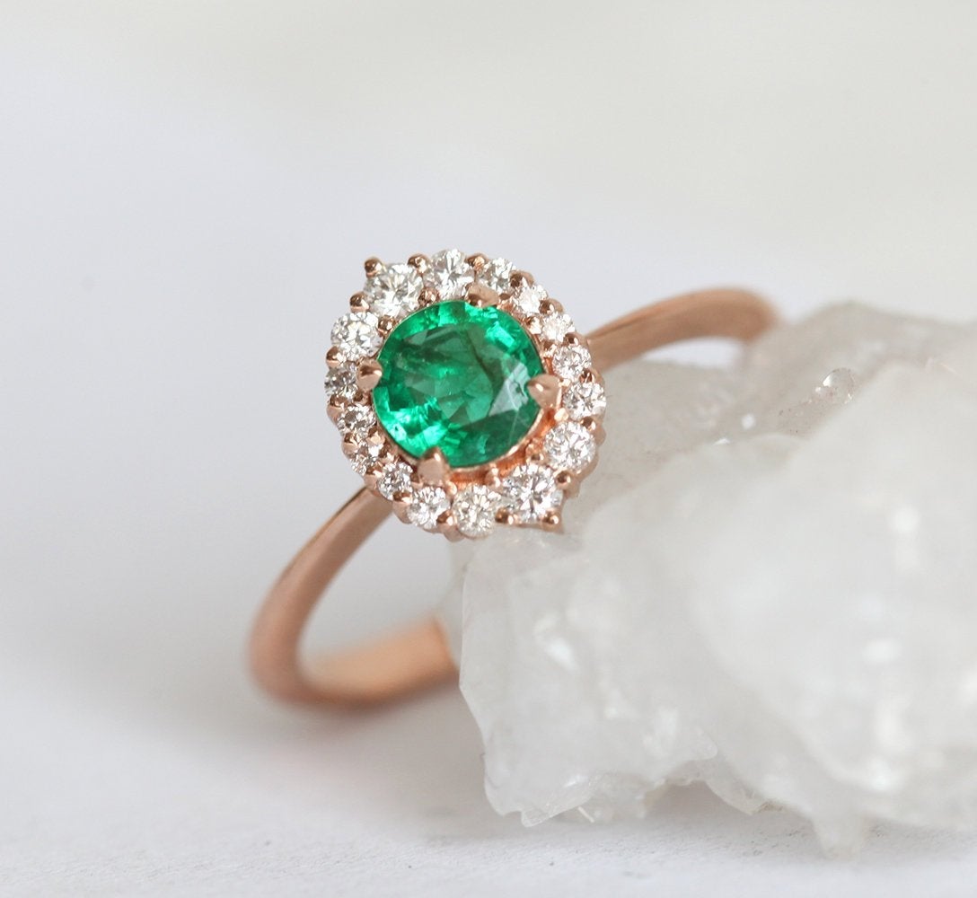 Capucinne’s Rose Gold Emerald Ring with Diamond Halo.