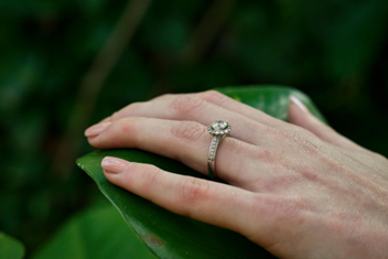 Diamond ring on hand, holding a leaf