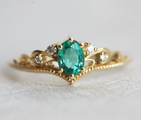 Un anillo de compromiso floral con pétalos de diamantes blancos y núcleo de zafiro naranja.