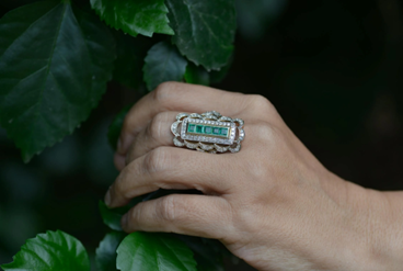 Emerald Engagement Ring on hand with green leaves