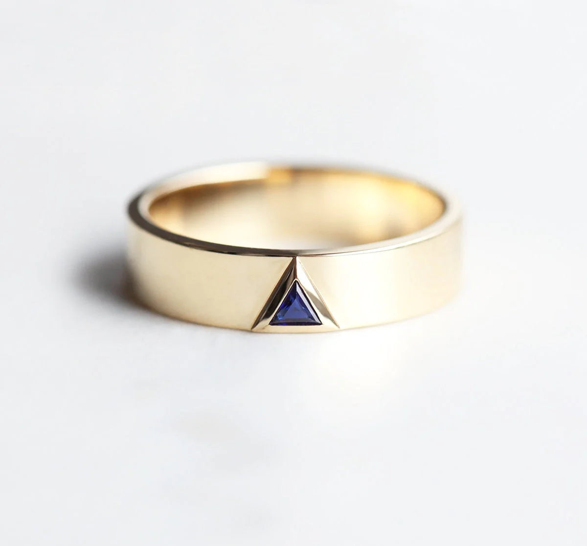 The Capucinne Triangle Sapphire Gold Ring makes a powerfully elegant, sleek, and simple holiday engagement ring.
