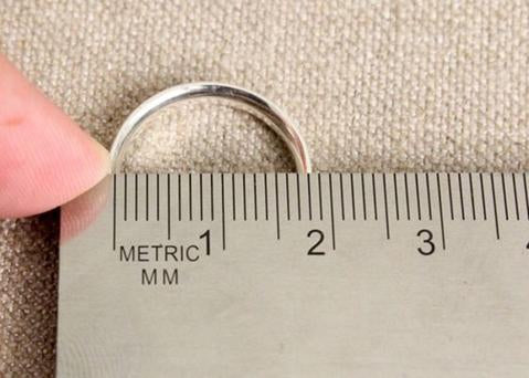 Someone measuring the inside diameter of a ring with a ruler in millimeters