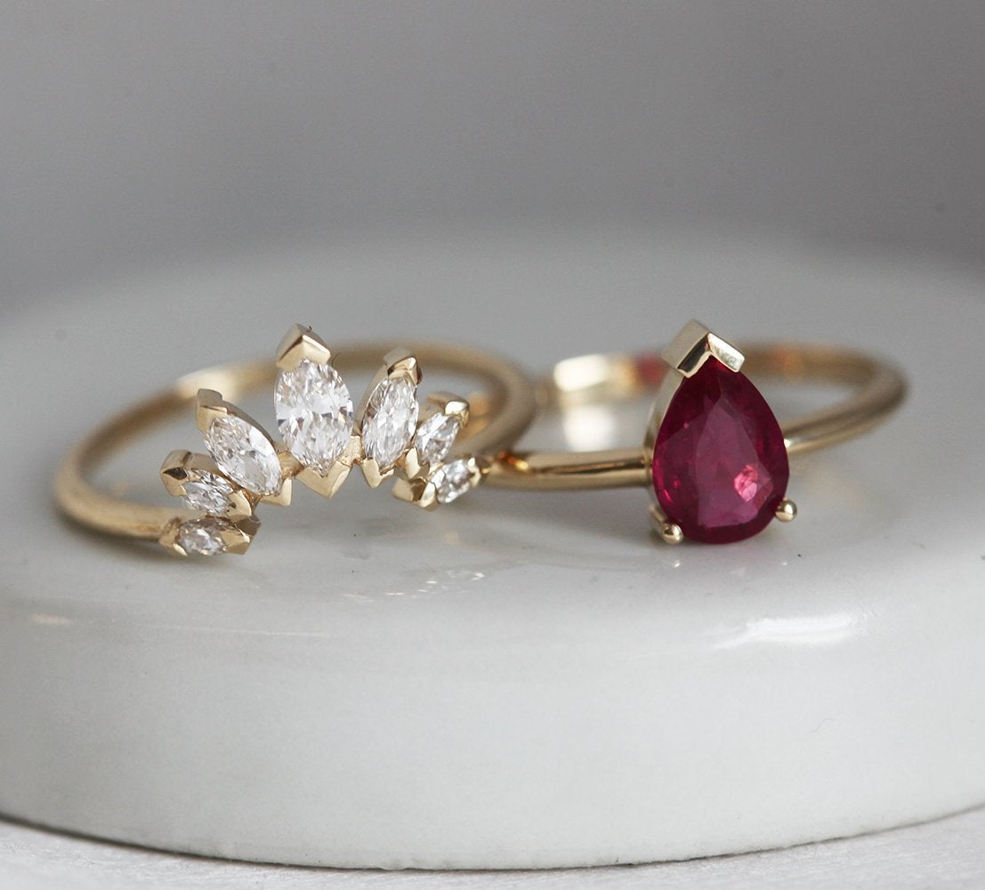 La parure de fiançailles Korina Natural Ruby avec une bague en rubis et une bague en couronne de diamants présentées séparément.