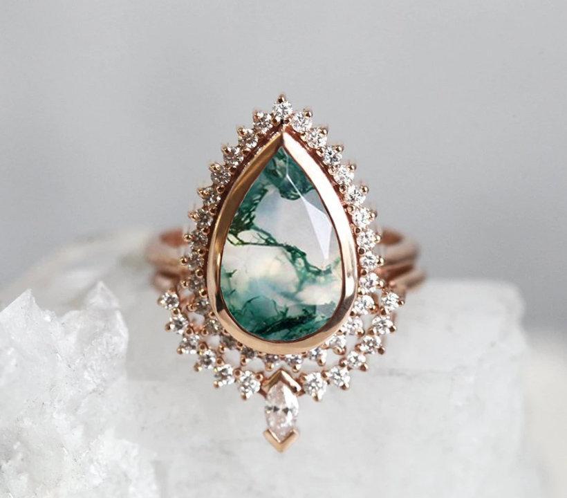 Un delicado anillo de ágata de musgo de pera engastado con diamantes.