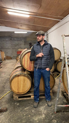 PROFILE PICTURE NATURAL WINEMAKER ROMAIN LE BARS SOUTH OF FRANCE IN FRONT OF BARRELS WITH TASTING GLASS