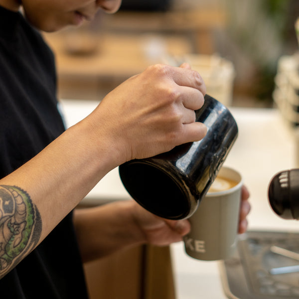 Specialty coffee barista pouring latte art 