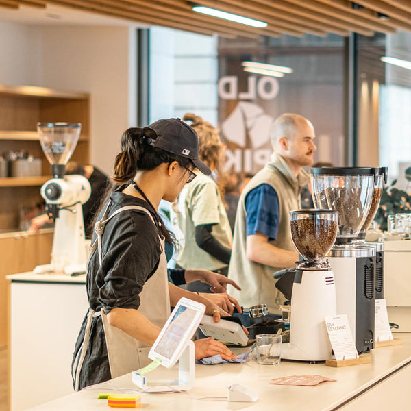 Baristas working in a coffee shop behind a coffee bar