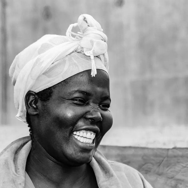 Black and white photo of a Kenyan woman in a headscarf laughing