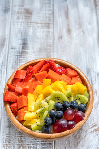 Breakfast oatmeal for kids topped with rainbow fruits stock photo