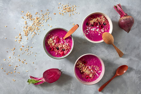 Healthy breakfast bowl with beetroot, oat flakes and berry on stone background, flat lay stock photo