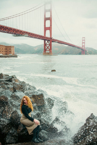 With waves crashing ashore near the Golden Gate Bridge, Flannery wears dress and shoes from Empress Vintage.