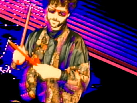 Yaniv Deridder in 1980s leather and textile patchwork jacket and Gianni Versace mirrored sunglasses for the Goddess Exotica music video.