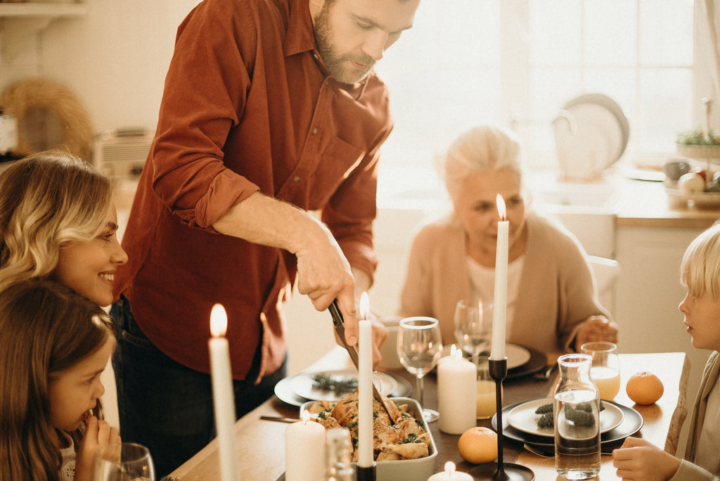 A beautiful family celebrates the holiday. Hot drinks from Tritan Unbreakable Stemless Wine Glasses. House party, family eating turkey.