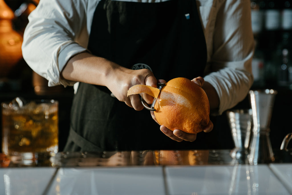 Man in a bar making a cocktail with whiskey