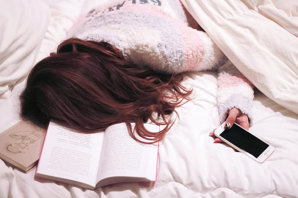 Girl sleeping on bed with phone
