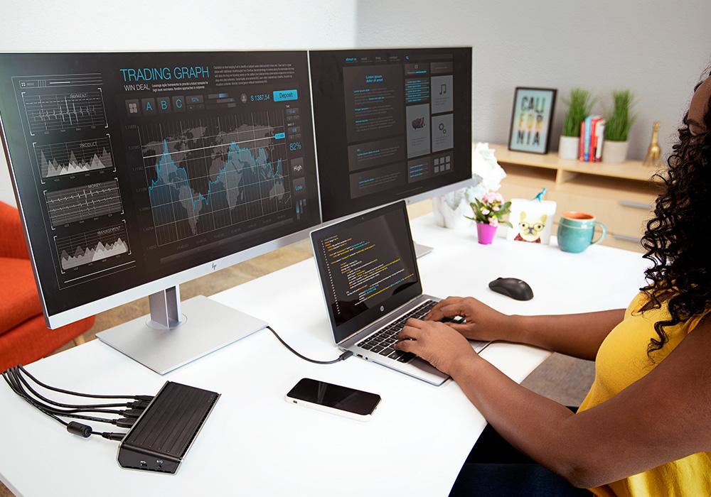 Woman working on a computer with multiple monitors