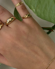 thin gold dome ring on woman's ring finger