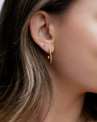 woman wearing gold twist hoop earrings
