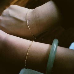 two friends with matching gold chain bracelets