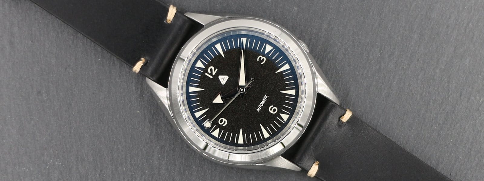 Seiko SNKL23 upravený s (i) ciferníkem BGW9 Nautical Explorer, (ii) leštěnými stříbrnými širokými šípovými ručičkami BGW9, (iii) oboustranným modrým safírovým sklíčkem AR na (iv) černým vintage italským telecím koženým řemínkem