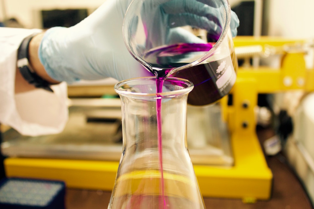 Chemical being poured into a conical flask