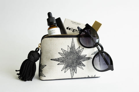 Image of KellyGreen Pouch No. 1 with Compass Star Print filled with cannabis products