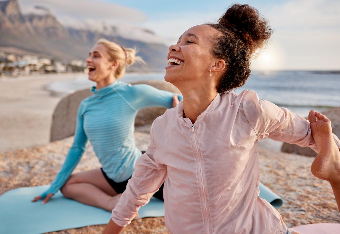a couple of women doing yoga and laughing on the beach human behavior mental health professionals clinical psychology holistic health person's past therapy person as a whole physical health relationships behaviors treatment therapy relationships therapy physical health relationships relationships