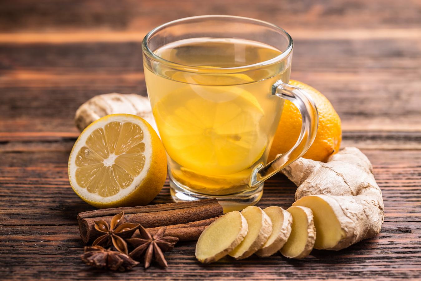 a cup of ginger tea surrounded by natural ingredients orange juice fresh ginger tea steep ginger tea help nutrition calories rolling boil ginger pieces saturated fat