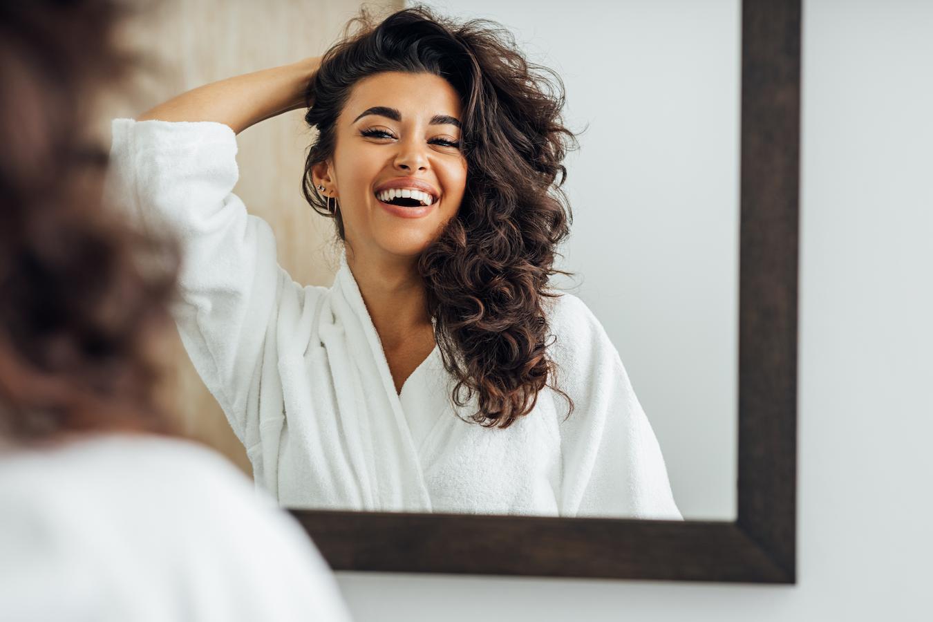 a girl smiling in the mirror practitioner's hands off client's body data suggests nervous system patient's body