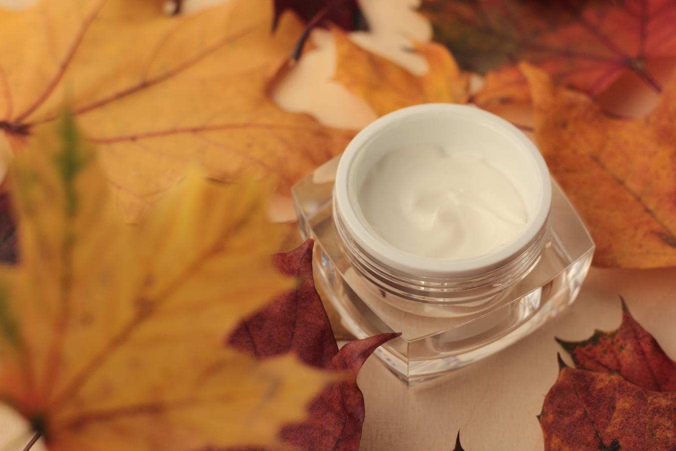 a glass jar of product on top of autumn leaves harmful uv rays wear sunscreen sun exposure at least spf body's largest organ face masks vitamin c combination skin care routine skin