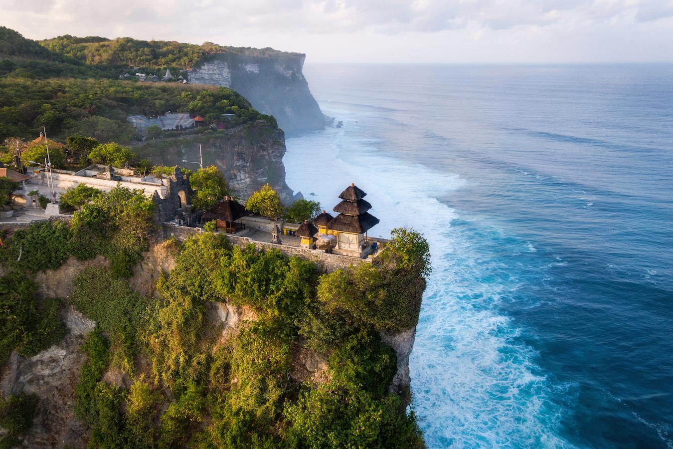 a temple on a green cliff by the ocean book accommodation early indonesian independence day indonesia's independence day kite flying full swing bali kites festival sun seekers rice terraces beautiful island good weather