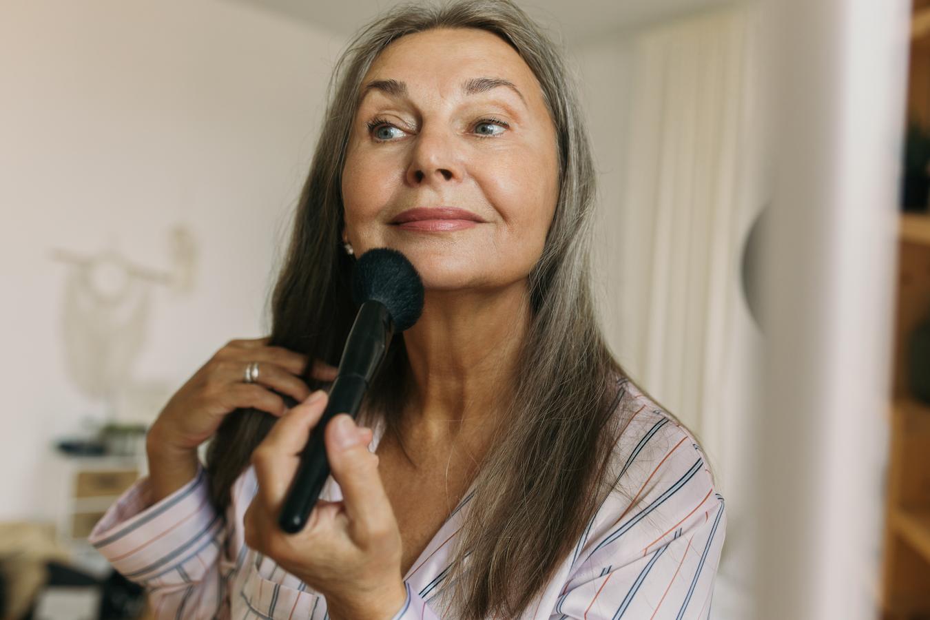 an elderly lady applying makeup says dr pores board certified dermatologist pores smaller pores