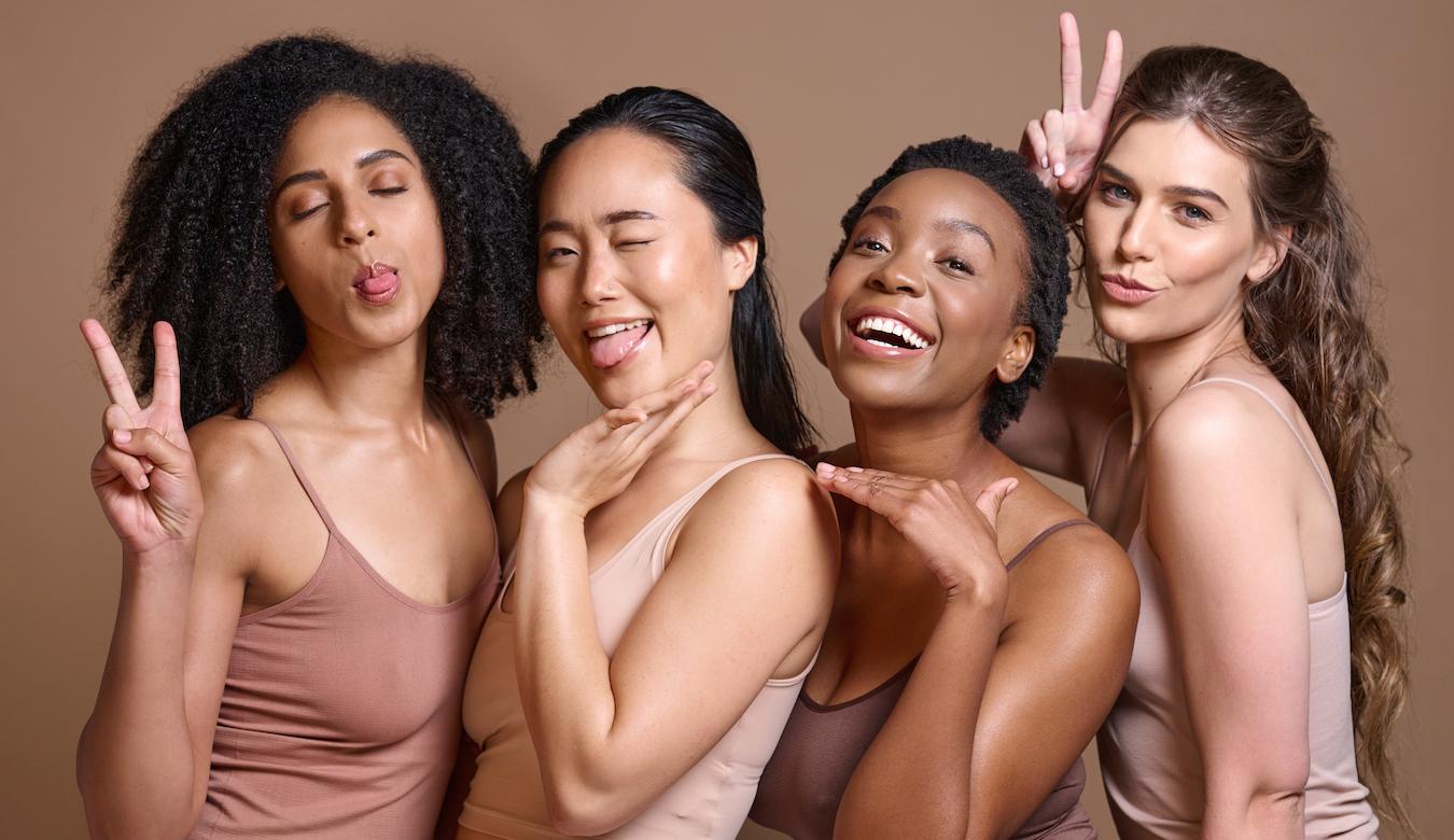 four women wearing neutral clothes smiling for the camera social creatures social connection social wellbeing social support mutually beneficial