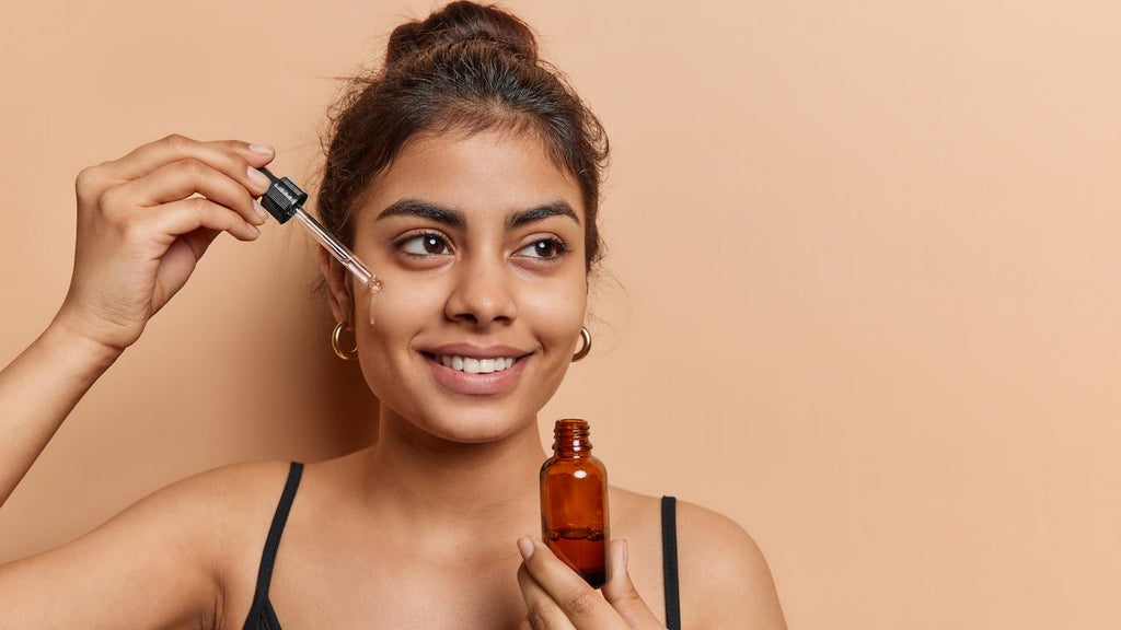 girl applying a serum to her face while smiling post inflammatory hyperpigmentation tea tree oil red blemishes on the face topical creams get rid of blemishes on the face lemon juice apple cider vinegar get rid of blemishes skin produces