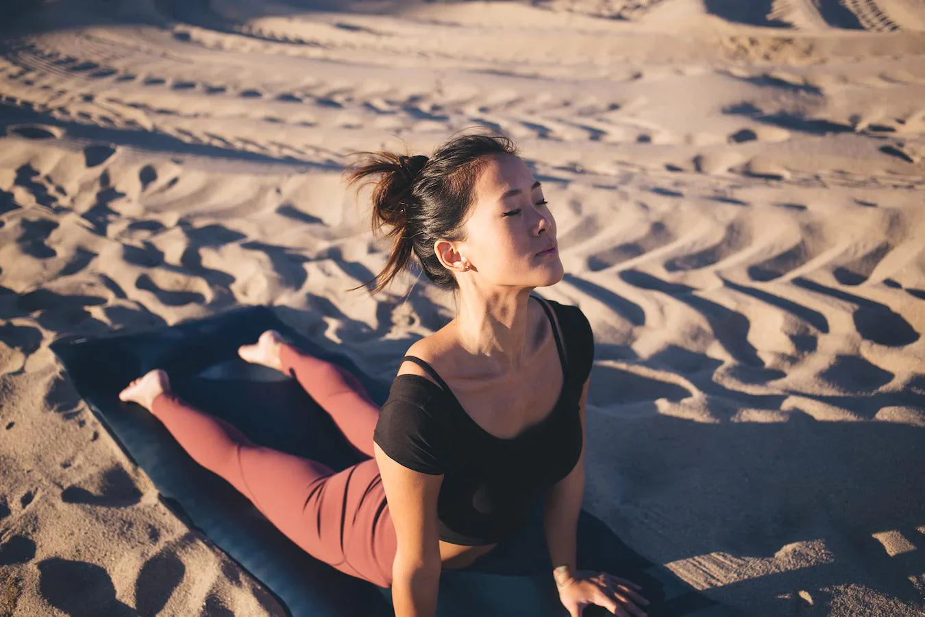 girl doing yoga on a beach