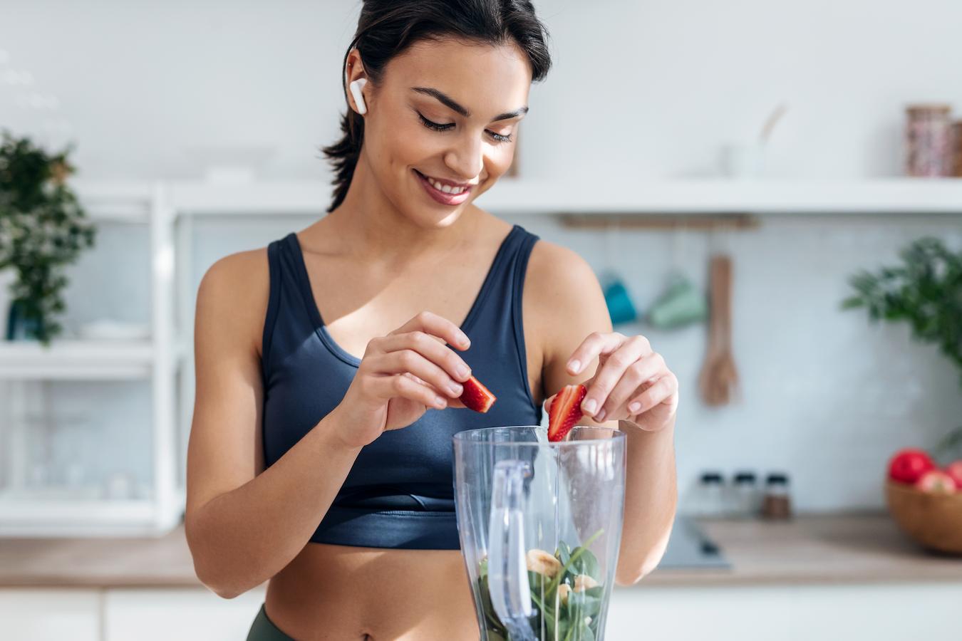 girl putting strawberries in a blender whole grains weight loss