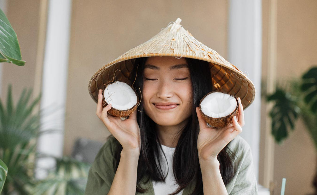 girl with coconuts smiling wearing a round hatglowing skin clog pores enlarged pores skin care for oily skin tiny pores oil free deep cleanses unclog pores premature ageing