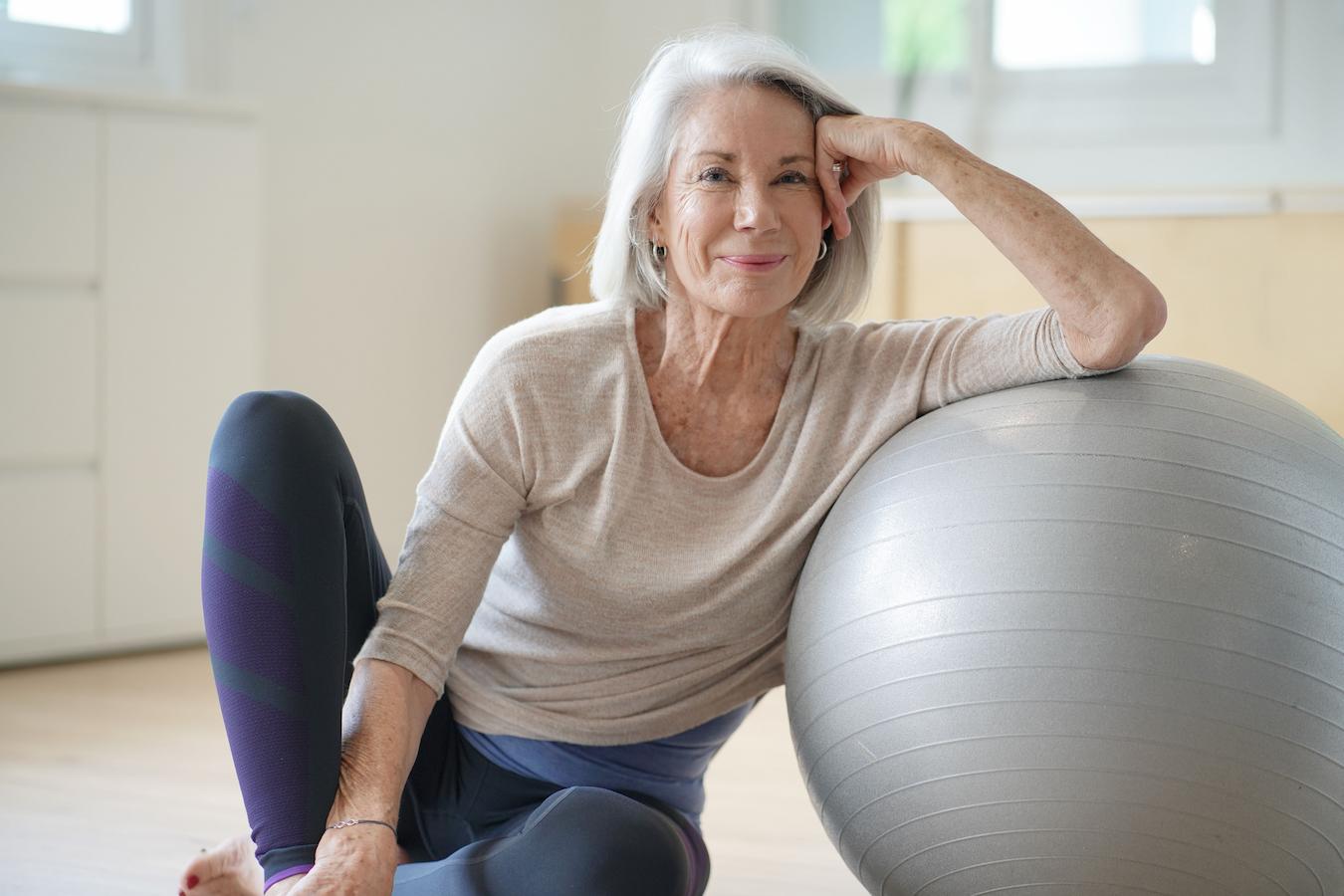 older lady smiling and leaning on a yoga ball carrier oil free radicals essential oil called hawaiian lei flowers quality products essential oil anti inflammatory