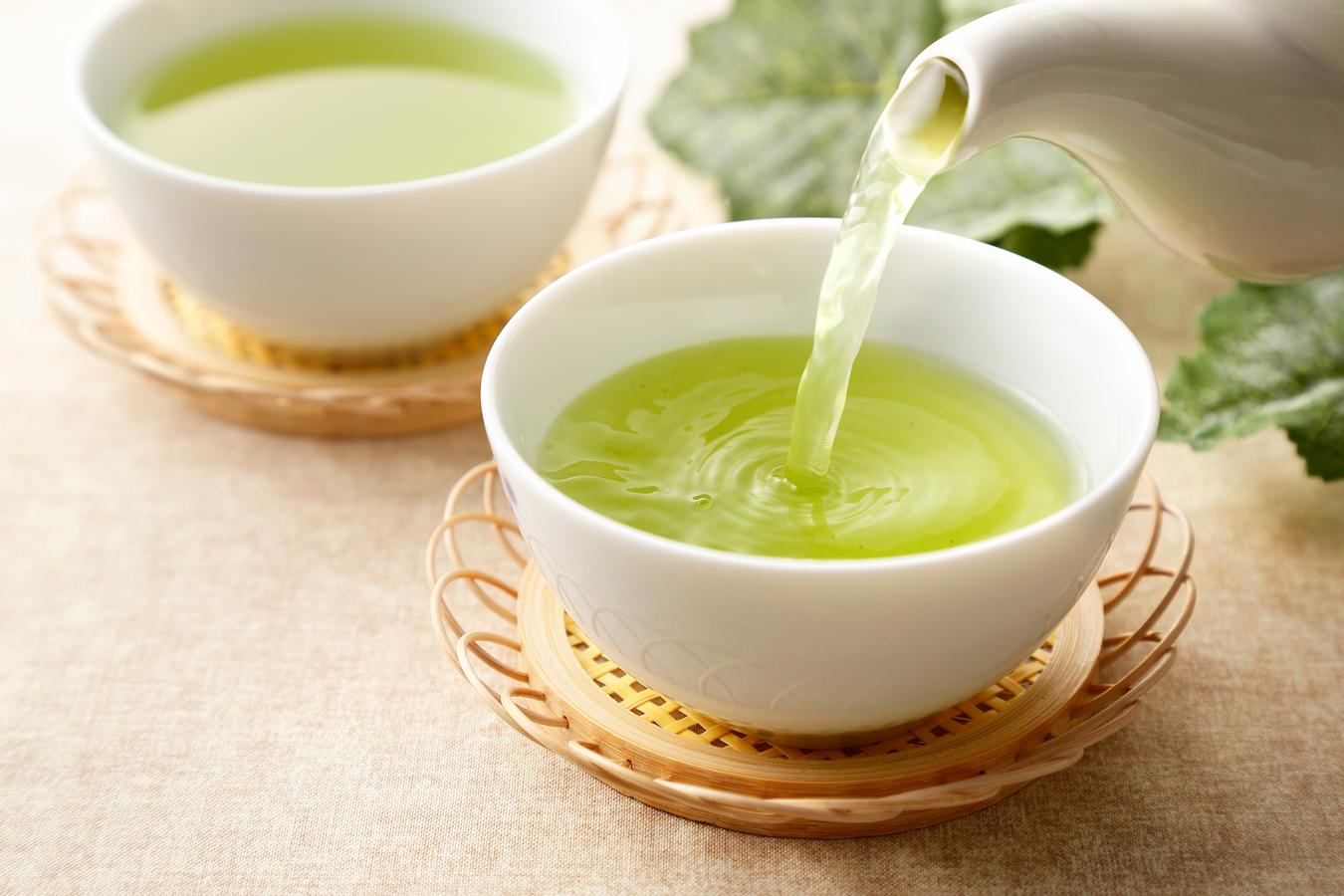 someone pouring a cup of green tea brewing green tea how to make green tea iced green tea leaves lemon juice brew green tea recipe add honey perfect cup