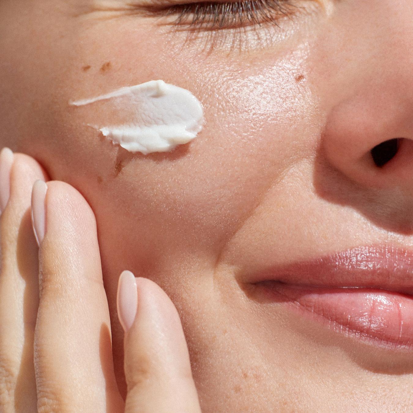 woman applying skincare product to her skin dark spots beta hydroxy acids