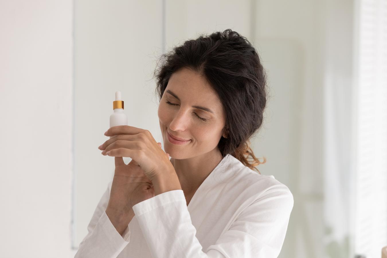 woman with perfume oil smelling it and smiling following essential oils immune system add essential oils grapeseed oil relieving pain possible sensitivity good scents muscle spasms muscle tone