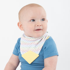 Baby wearing rainbow dots teether bib with yellow teether