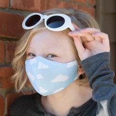 Girl wearing BooginHead mask blue sky