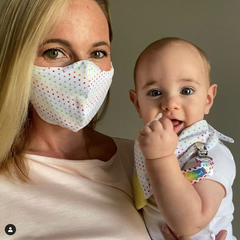 Mom wearing BooginHead face mask holding baby using BooginHead baby products